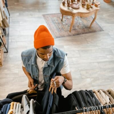 Overhead view of a man in a beanie browsing clothes in a boutique.
